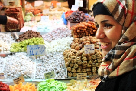 ISTANBUL - NOVEMBER 20: Unidentified woman bargains for Turkish Delight at Spice Market on November 20, 2010 in Istanbul. Nut, locum and souvenirs fill shops at here, one of the oldest bazaars in cityのeditorial素材