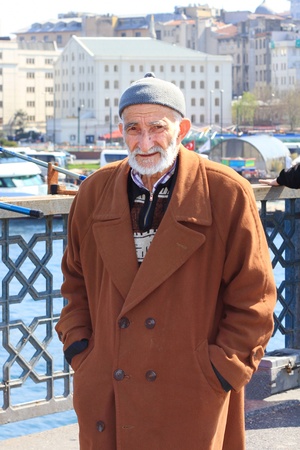 ISTANBUL - APRIL 12: Portrait of an unidentified senior Turkish man wearing traditional dress on Galata Bridge on April 12, 2012 in Istanbul. The bridge is major strolling and tourism center in city.のeditorial素材