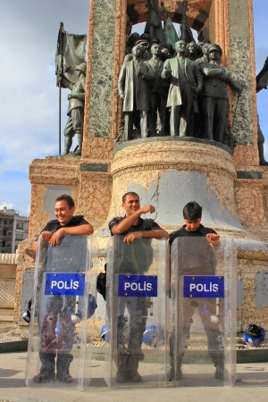 ISTANBUL - JUN 12: Plans to build on Gezipark led to anti government unrest on June 12, 2013 in Istanbul, Turkey. Riot police wait in front of Independence Monument whilst protesters occupy the park.のeditorial素材