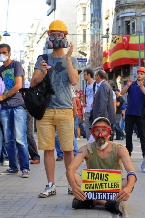 ISTANBUL - JUN 17: Labor unions call 1-day nationwide strike over crackdown on June 17, 2013 in Istanbul, Turkey. A demonstrator holding banner sits down on the street during the portest.のeditorial素材