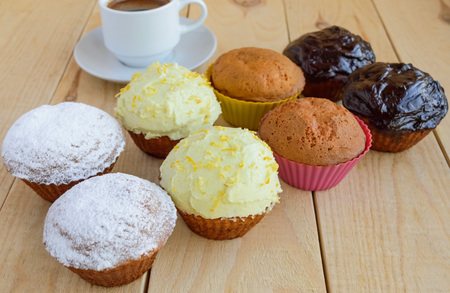 Holiday cupcakes muffins on many kinds of wooden background and a cup of coffee.の写真素材