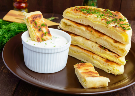 Traditional Georgian cheese pie - khachapuri, creamy sauce. The national cuisine of Georgia.