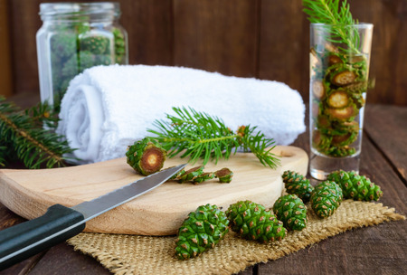 Young green fir cones on the wooden background. Chopping knife cones for making medicinal infusion.の写真素材
