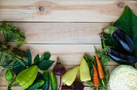 Freshly picked vegetables and herbs on a wooden background. top view