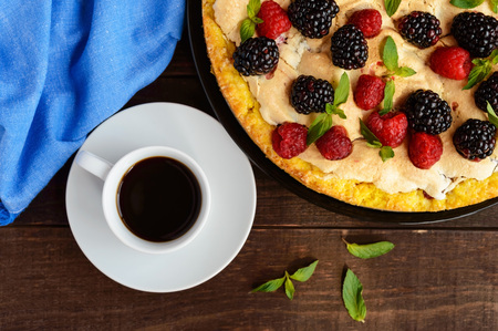 Pie (Tart) with fresh blackberries and raspberries, air meringue, decorative mint and cup of coffee
