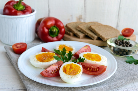 Boiled egg and fresh tomato, black bread - light diet breakfast.の写真素材