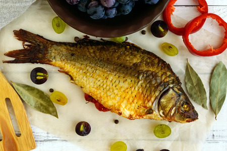 Baked fish carp, stuffed bell peppers and grapes.の写真素材