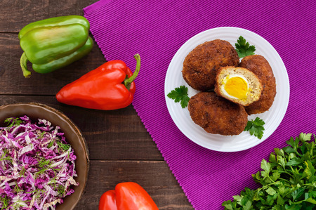 Meat mini-rolls (cutlet) with boiled egg on dark wooden background. The top view.の写真素材