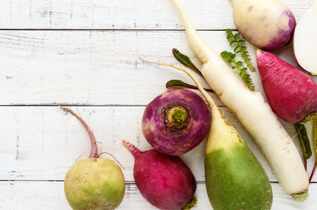 Several kinds of radish (daikon, Chinese red, green) on white wooden background. Useful vitamins ingredient for salads. The top view.の写真素材