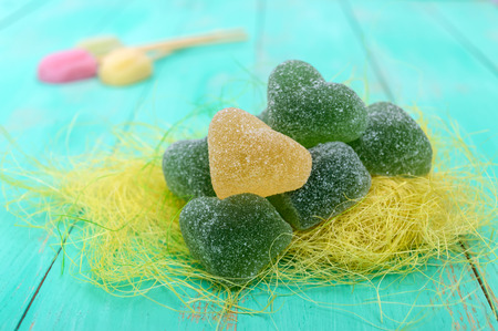 Green and yellow jelly candy heart shaped sugar decoration on a bright spring background. Holiday St. Valentines. Mothers Day.の写真素材