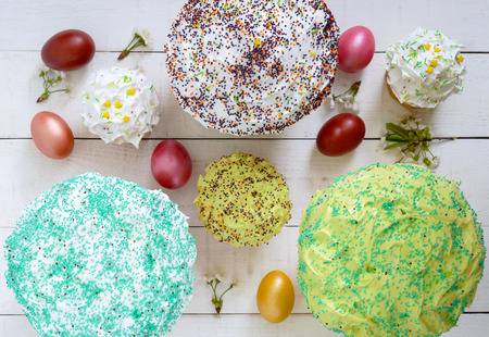 Easter cake kulich with glaze, colorful sugar sprinkles. Colored painted eggs. Beautiful traditional...