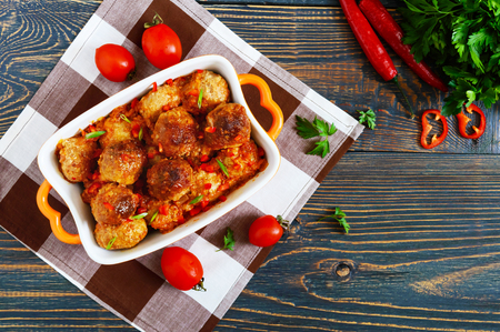 Juicy meatballs in a spicy tomato sauce on a wooden table. Dish from minced meat. The top viewの写真素材
