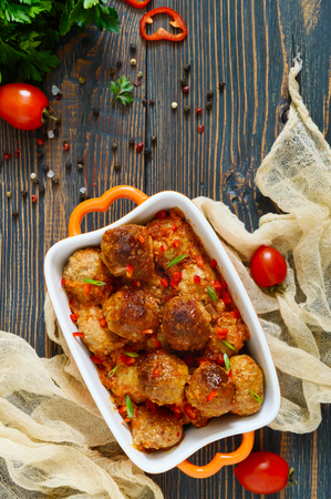 Juicy meatballs in a spicy tomato sauce on a wooden table. Dish from minced meat. The top viewの写真素材
