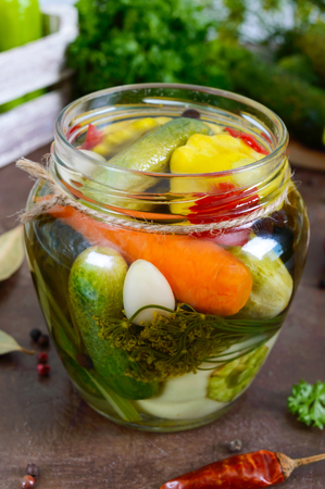 Marinated vegetables in a glass jar. Assorted cucumbers, peppers, carrots, patissons, zucchini. Pickles.の写真素材