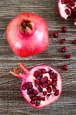 Ripe pomegranate fruit for making fresh pomegranate juice on wooden table. Healthy eating concept. The top viewの写真素材