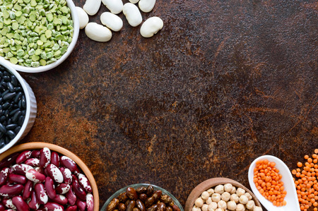 Healthy food, dieting, nutrition concept, vegan protein source. Assortment of colorful raw legumes: lentils, green peas, beans, chickpeas in bowls. Background. Free space.の写真素材
