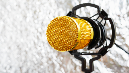 Beautiful golden microphone on a light blurred background, close up, bokeh.の写真素材