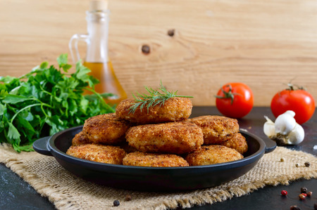 Juicy homemade cutlets (beef, pork, chicken) on a black background.