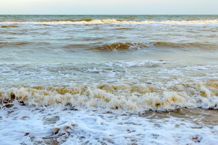 Waves on the shore. Sea wave close up on a sandy beach with sunlight.の写真素材