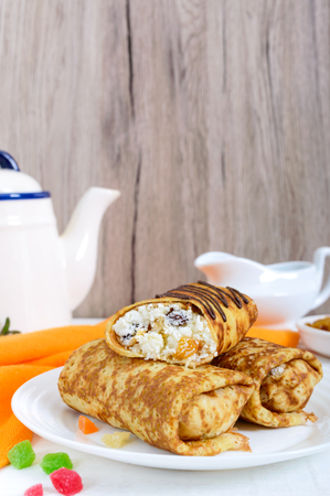 Delicious delicate pancakes with cottage cheese and raisins on a white wooden background. Healthy breakfast. Vertical viewの写真素材