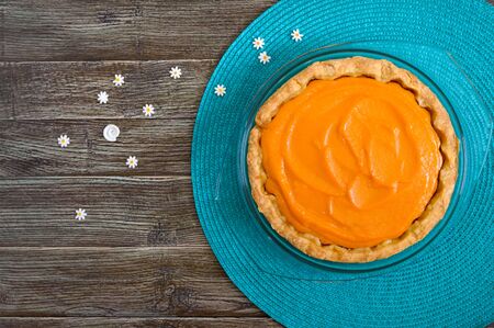 Traditional homemade pumpkin pie on a wooden table. Healthy food, dessert for gourmets. Thanksgiving theme. Traditional autumn baking. Top view.の写真素材