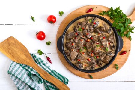 Turkey liver with onions and mushrooms in a creamy sauce on a white wooden background. Diet menu. Top view.の写真素材