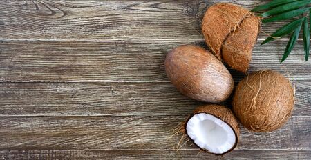 Coconut Whole coconut, shell from coconut and green leaves on a wooden background. Big nut. Tropical fruit coconut in the shell. SPA Food photo. Photo background. Texture tropical fruit.の写真素材