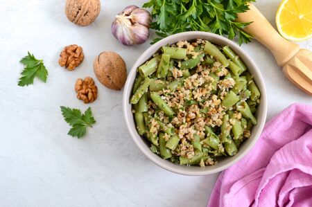 Salad with green beans and spicy walnut sauce in a bowl. Vegetarian, vegan menu. Top view.の写真素材