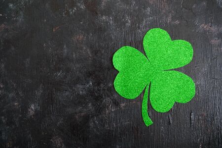 Green shamrock on a black background. St.Patrick 's Day background. Symbol of Ireland. Copy space.の写真素材