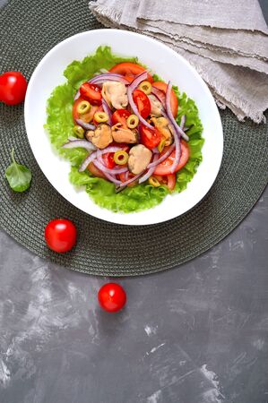 Salad of marinated mussels, fresh tomatoes, red onions, olives in a white bowl. The top viewの写真素材