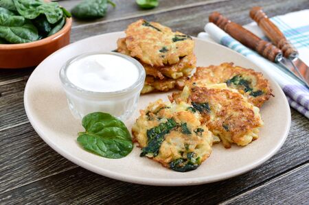 Pancakes with cabbage and spinach. Juicy vegetable cutlets on a plate with sour cream. Diet menu. Lenten dish.の写真素材
