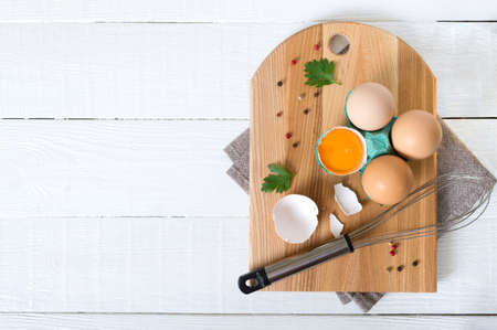 Fresh raw chicken eggs in an cartons egg box. Broken egg, yolk. Organic food for good health high protein. The top view, flat lay. Copy spaceの写真素材