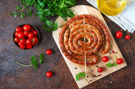 Delicious homemade sausages, baked rings on skewers, with cherry tomatoes. Oktoberfest snack. Summer picnic dishの写真素材