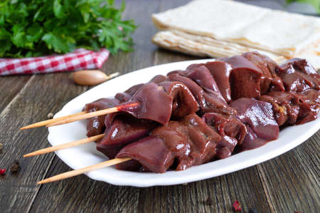 Pieces of raw pork liver on wooden skewers for cooking barbecue. Diet dish. Asian cuisine.の写真素材