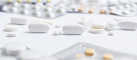Heap of different pills, in blisters and scattered on white background. Pharmacy and healthcare...