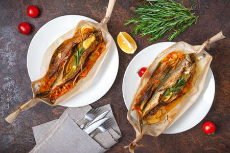 Fish with vegetables. Whole herring with lemon, onion, carrot and rosemary baked in the form of a...
