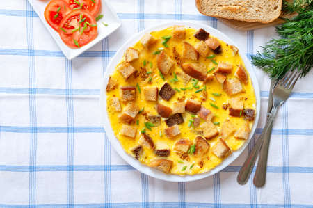 Omelet with pieces of bread and cheese. Delicious and nutritious breakfast. Top view.