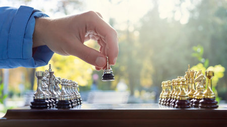 Outdoor chess game. Chessboard with figures, close-up. The pawn makes the first move. Selective...