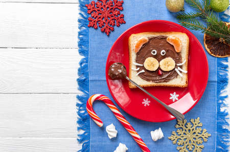 Kids sandwich in a shape of tiger made of fresh fruits and chocolate on a plate with copy space. New Year, Christmas food. Top view.の写真素材