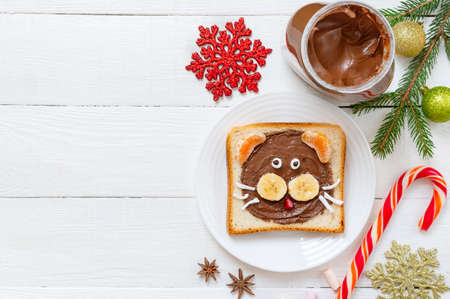 Chocolate sandwich in a shape of tiger - edible symbol of 2022 year. Christmas breakfast theme, copy space. Toast with fresh fruit and cocoa spread for kids. Top viewの写真素材