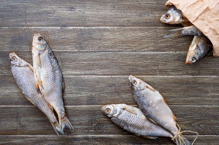 Salted dried fish on a wooden table with copy space. Traditional beer snack. Top view, flat layの写真素材