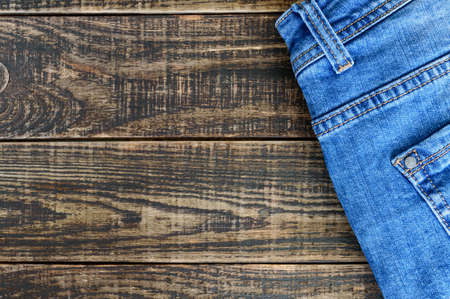 Blue cotton jeans on a rustic wooden background with copy space.の写真素材