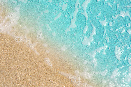 Soft blue ocean wave on clean sandy beach. background with copy space. selective focus. travel...