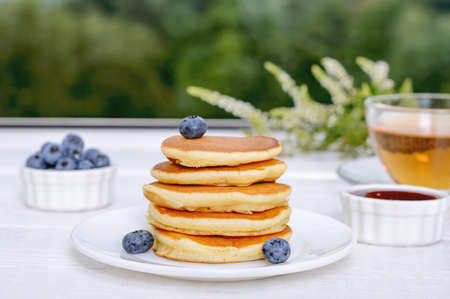 Delicious pancakes with fresh blueberries, jam, tea. Breakfast.