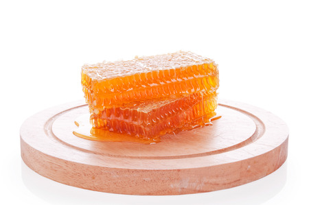honeycomb on a wooden board isolated on white backgroundの写真素材