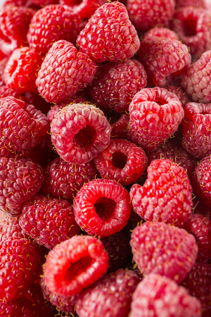 A beautiful selection of freshly picked ripe red raspberries.の写真素材