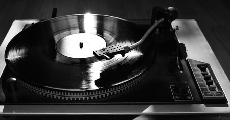 Turntable playing vinyl close up with needle on the record with grey backgroundの写真素材