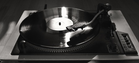 Turntable playing vinyl close up with needle on the record with grey backgroundの写真素材
