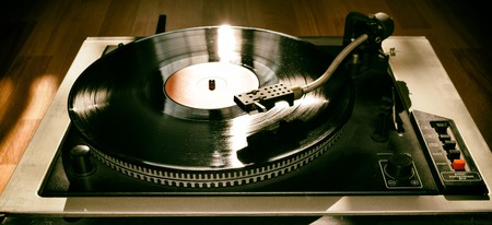 Turntable playing vinyl close up with needle on the record with grey backgroundの写真素材