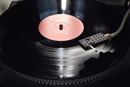 Turntable playing vinyl close up with needle on the record with grey backgroundの写真素材